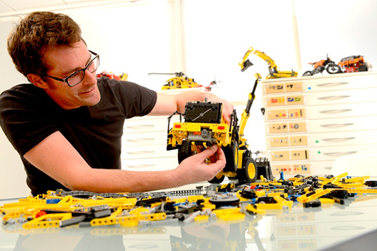 Руководитель конструкторского отдела LEGO Technic собирает модель колесного погрузчика Volvo L350F